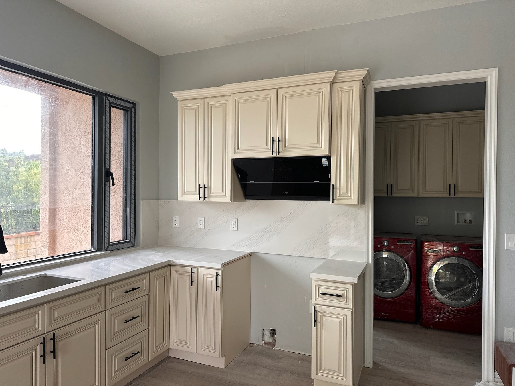 Classic Antique White kitchen cabinetry beside utility room